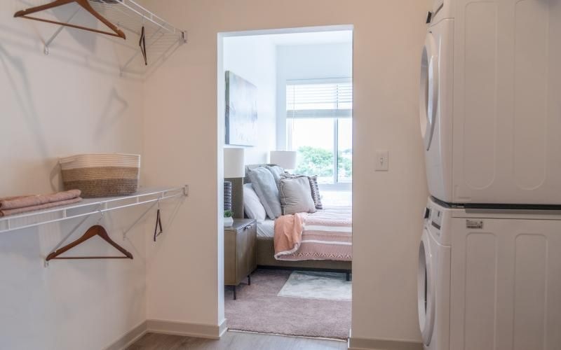 closet leading to a bedroom with a bed and a window