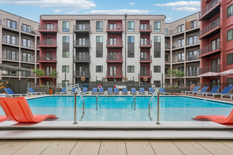 a pool and chairs in a courtyard