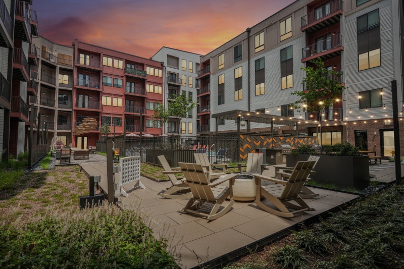 a community patio with seating and fire pit in a courtyard